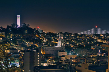 The landmarks Coit Tower and Bay Bridge at night in San Francisco, CA. (USA)