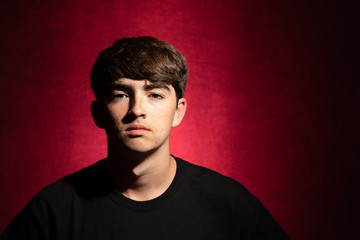 Fototapeta premium Young man portrait on a red background