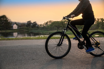 Fototapeta premium A middle woman active biking in the park at sunset background.
