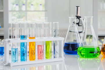 Test tubes and beakers in white laboratory with microscope no people.