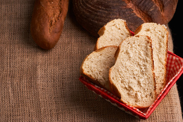 Top view of sliced wholegrain bread on dark ructic wooden background closeup