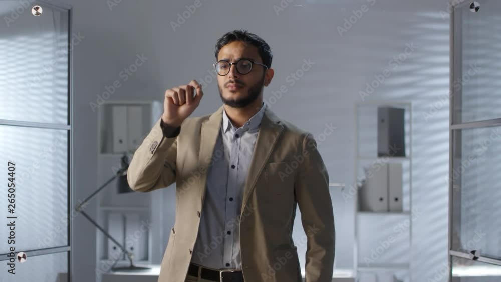 Poster intelligent middle eastern businessman in glasses tapping and swiping on invisible augmented reality