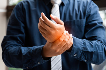 Closeup business man holding wrist pain. Health concept, Office syndrome. 
