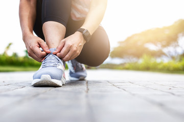 Naklejka premium Young woman tying jogging shoes.