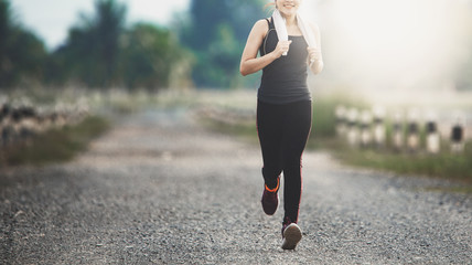 young fitness woman running on the road in the morning.. - 265057025