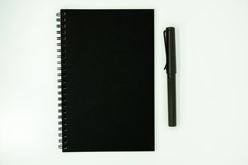 Top view open spiral notebook with pen on white background.