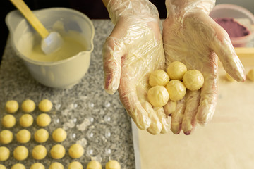 The process of making handmade chocolates. Round chocolate candies in the hands of the pastry chef....