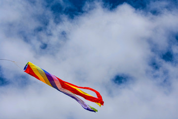 Wind direction indicator shows which direction the wind is blowing. Background cloud and blue sky