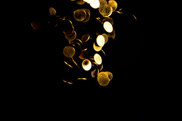Falling gold coins money in dark background, business concept.