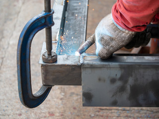 Professional welder welding metal and many fire sparks in the industrial workshop. welder welding metal. sparks metal
