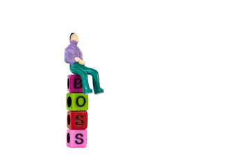 Businessman or manager or boss sitting on BOSS text made from colorful beads or letter bead on white background, finance and business concept.