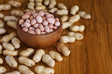 Peanut in wooden bowl on classic wooden table background