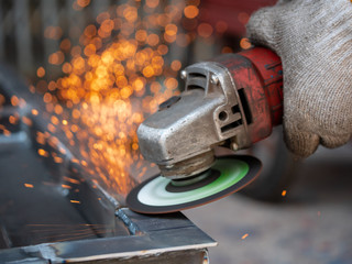 Close-up view of cutting steel shape, huge amount of sparks. Angle grinder sparks angle grinder cutting steel. Cutting steel with angle grinder. Worker cutting metal