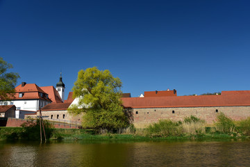 Naklejka na ściany i meble alte historische stadtmauer mit dächern der altstadt vor blauem himmel in bayern