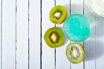 anti aging revitalizing gel and kiwi on white wooden
