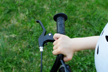 Red bicycle black steering wheel or rudder with brakes on green lawn grass background  outdoors in spring day.