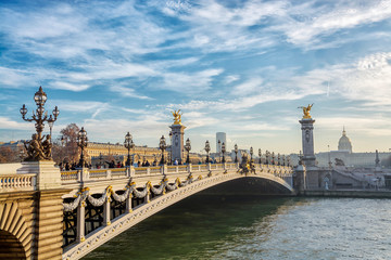 Fototapeta na wymiar View on the Bridge of Alexandre III and and Les Invalides across Seine River in Paris at evening, France.