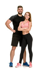 Fit happy couple: strong muscular man and slim woman posing on white background