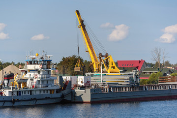 Loading barge with sand and rubble on a small berth. Freight transport logistics. Russia, Moscow region, August 2108.