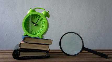 clock and books on wooden table