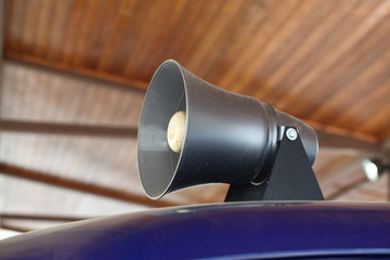 A flashing light and a loudspeaker on a police car.