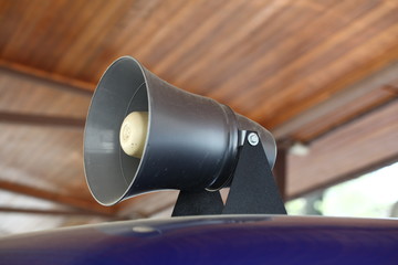A flashing light and a loudspeaker on a police car.