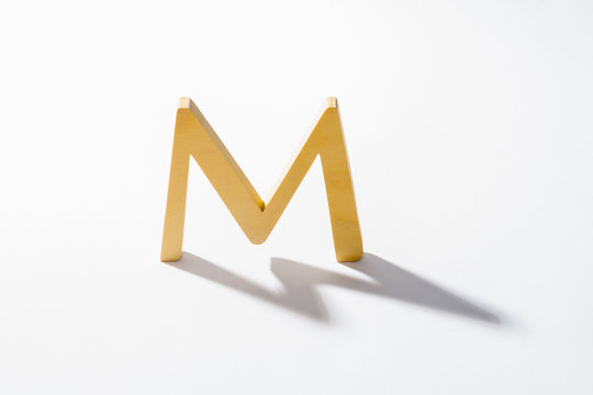 Wooden Alphabet M and Shadow Reflection.
