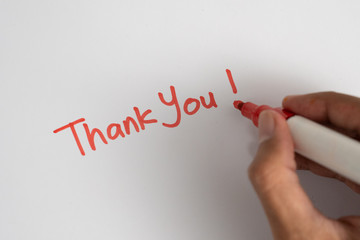gesture of hand writing thank you on white paper