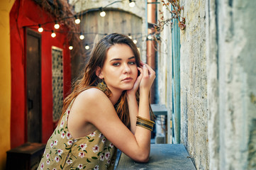 Fototapeta premium Portrait of a young woman on a city street . Girl dressed in retro dress