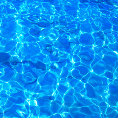 Obraz premium Blue clear water with rippled surface and sand bottom.