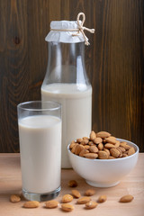 Glass of Milk Almond milk and organic almonds on wooden background, Alternative Milk. Nuts milk