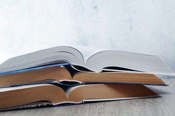 A stack of big study open books