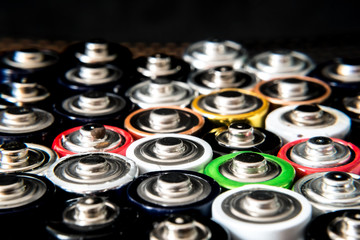 used disposable drain batteries of various size and color on black background