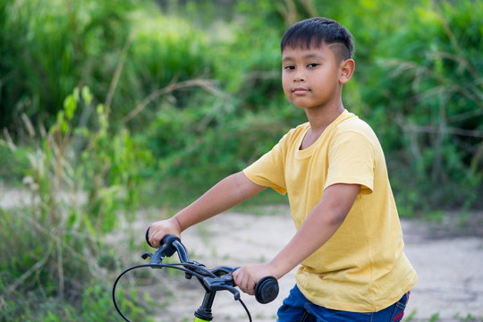 Asian Kid Boy Ride Bicycle In Nature