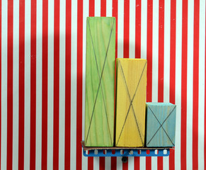 Colorful wood blocks of different size placed on a board that tgradually tilts, one by one they fall. The background lines are vertical reference (series of 4) - obrazy, fototapety, plakaty
