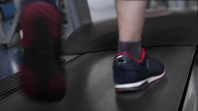 fitness club man engaged in walking. close-up of foot. strengthening leg muscles by walking. cardio load. man trains on a treadmill. walking in the gym. sports lifestyle concept. weight loss in gym.