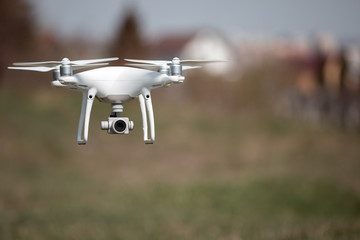 Close up on white drone camera. Drone quadcopter in flight