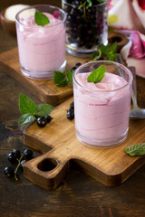 Homemade  black currant mousse on rustic wooden table. Delicious summer dessert. Copy space.
