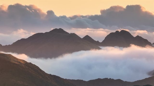 Clouds over foggy mountains landscape in sunny evening in New Zealand nature Time Lapse