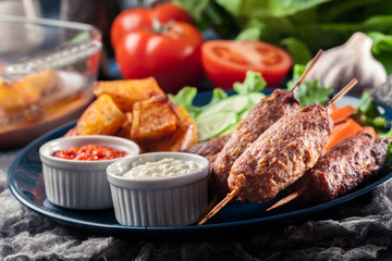 Grilled shish kebab served with fried potatoes