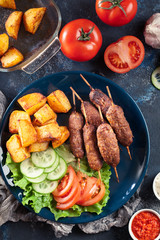 Grilled shish kebab served with fried potatoes