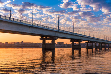 Fototapeta na wymiar Bridge over the river at sunset - a beautiful evening landscape, Saratov Bridge across the Volga.