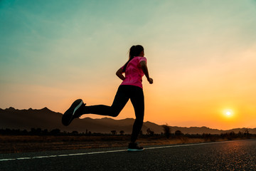 Young woman enjoys running outside with beautiful summer evening in the countryside.