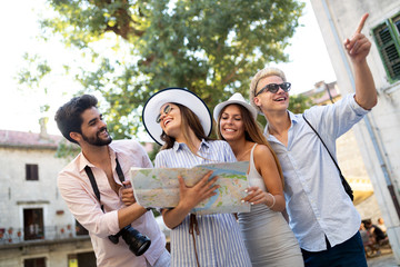 Happy group of tourists traveling and sightseeing together at summer