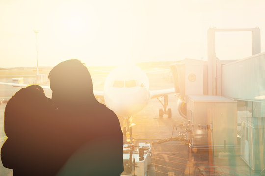 Couple Kiss Near Window In Airport. The Concept Of Meeting Or Parting Two People