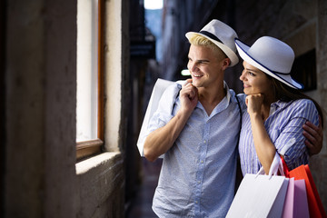 Fototapeta premium People,sale,love and happiness concept. Portrait of a couple with shopping bags in the city.