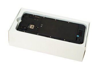 Fototapeta premium Broken black phone in a white cardboard box waiting for its repair in the service center isolated