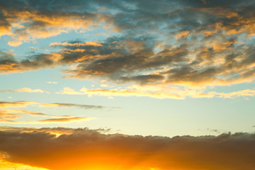 Stunning beautiful sky at dusk or dawn with sunlit clouds. Sunrise with sunshine, sky with clouds and sun in the sky.