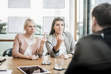 Stinkefinger im Büro bei der Besprechung