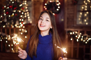 Portrait of a child girl looks with sparklers in their hands